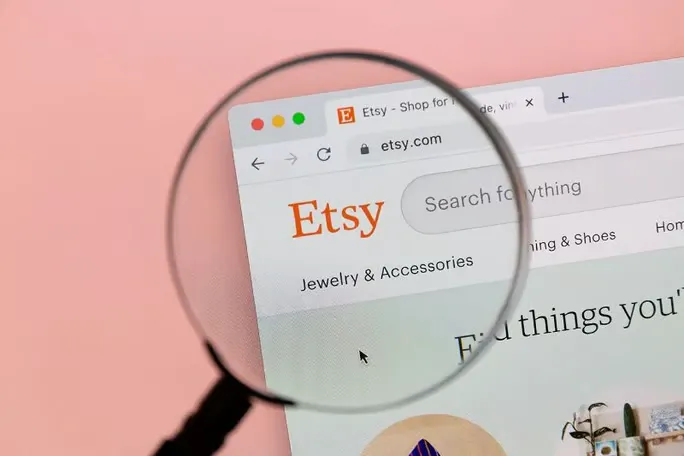 Magnifying glass looking at Etsy homepage.