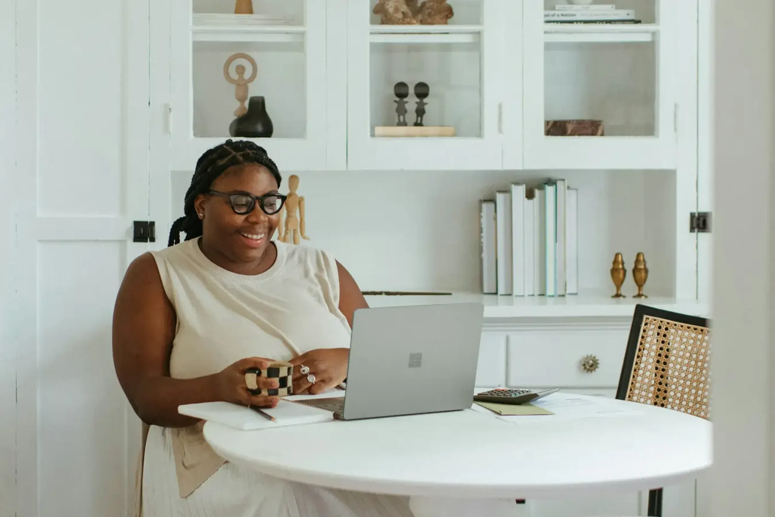 Woman smiling at computer while sitting at a desk.