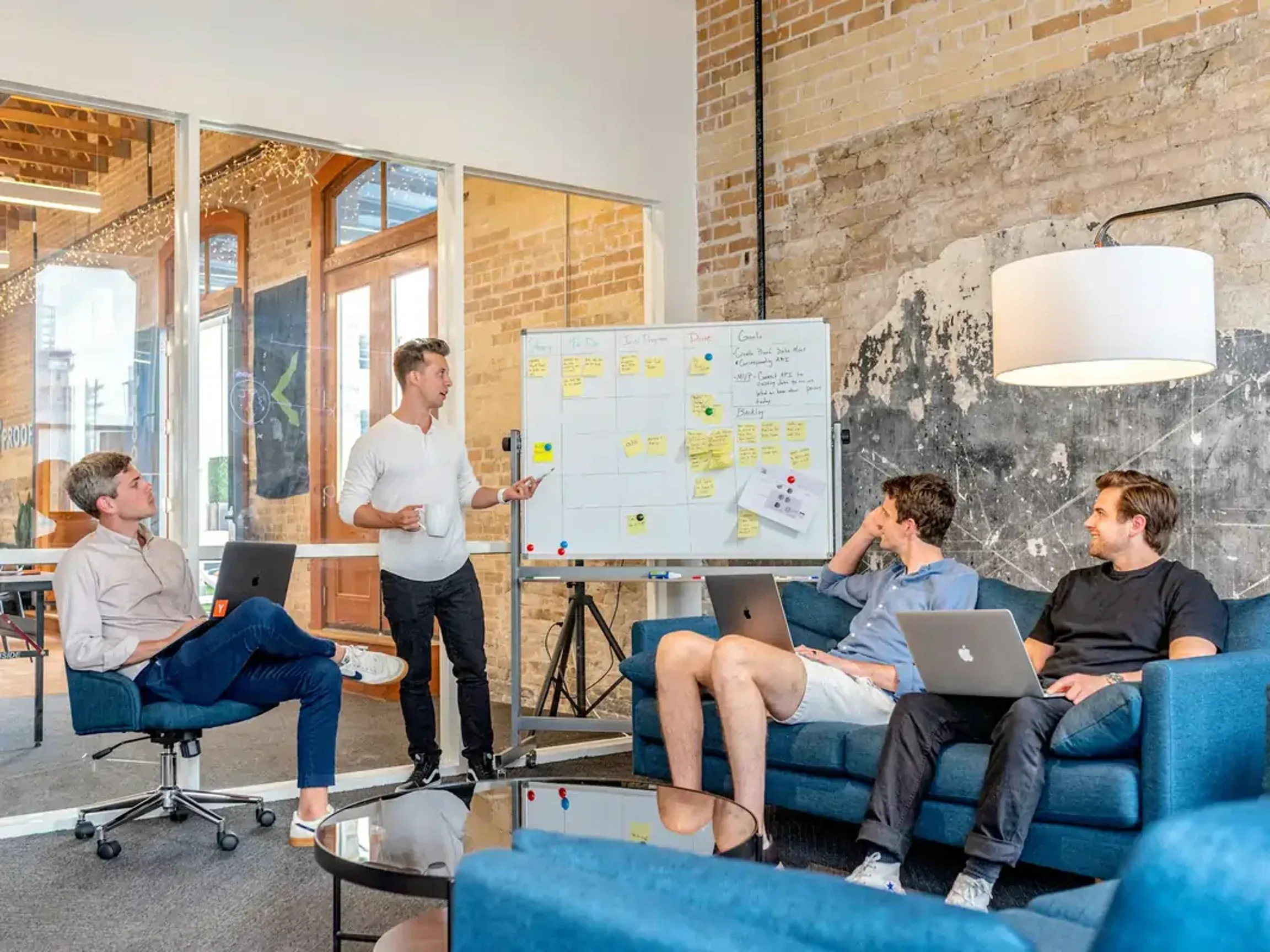 Team gathering in the workplace with a whiteboard.